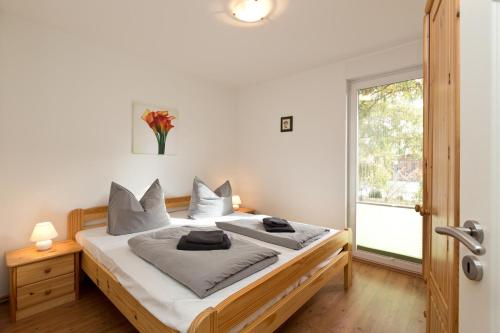 a bedroom with a bed with white sheets and a window at Kiebitz in Röbel