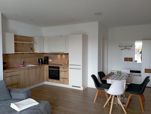een keuken en woonkamer met een tafel en stoelen bij Seerose in Malchow