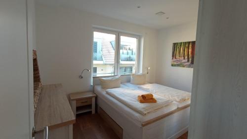 een witte kamer met een bed en een raam bij Seerose in Malchow