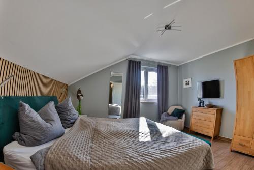 a bedroom with a bed and a dresser and a television at Green Eagle Lodge in Lebbin