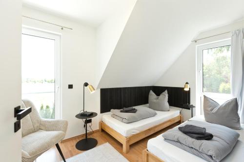 een woonkamer met 2 bedden en een stoel bij Seegasse in Unter Göhren