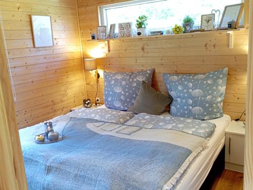 a bedroom with a bed with a blue comforter at Tiny House "Wolke 7" in Göhren-Lebbin
