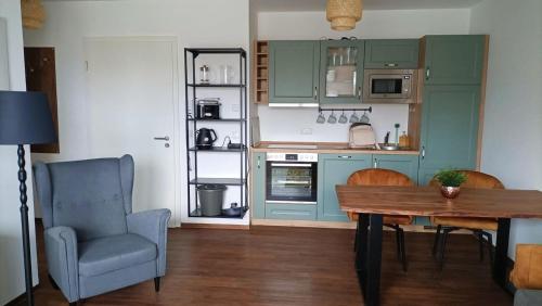 a kitchen with green cabinets and a table and a chair at Am Hafen 15 in Röbel