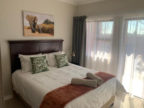 En eller flere senge i et værelse på OR Tambo Self Catering Apartments, The Willows