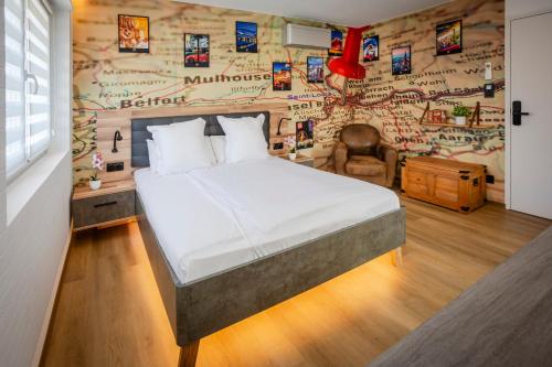a bedroom with a bed and a wall with pictures at Explorer, Proche Basel, Voyage, Style & Confort in Saint-Louis