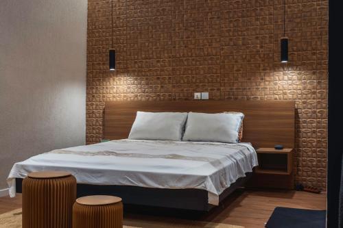a bedroom with a bed with a brick wall at Studio Spacieux et Moderne à Bietry in Abidjan