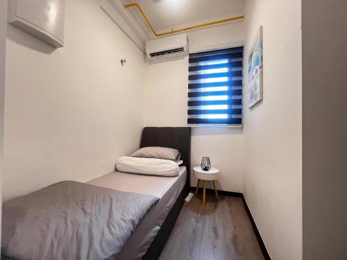 ein kleines Schlafzimmer mit einem Bett und einem Fenster in der Unterkunft CasaAntara by MySky Stays Putrajaya in Putrajaya