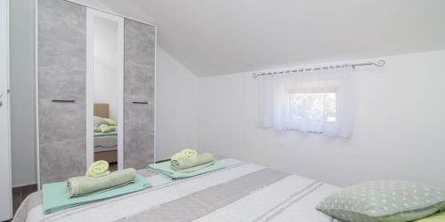 a white bedroom with a mirror and a bed at Tia in Veli Lošinj