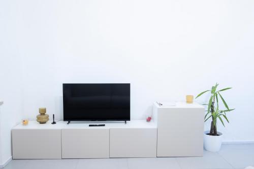 einen TV auf einem weißen Schrank im Wohnzimmer in der Unterkunft Rosmaris - Villa nel verde in Francavilla al Mare