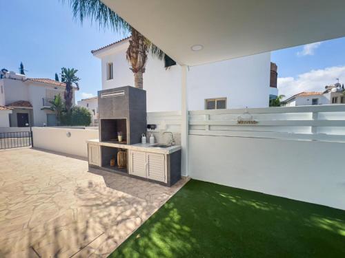 a backyard with a grill and a green lawn at Villa Allegra in Protaras
