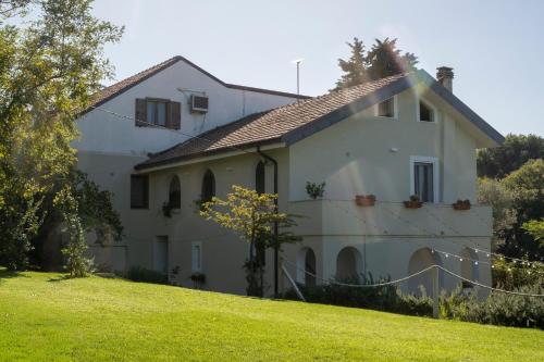 ein weißes Haus auf einem grasbewachsenen Hügel in der Unterkunft Rosmaris - Villa nel verde in Francavilla al Mare