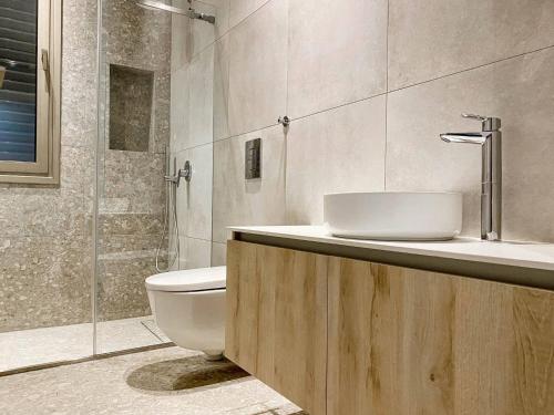 a bathroom with a toilet and a sink and a shower at Azure Villas by Marc in Paralimni