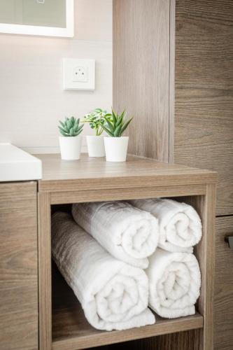 a pile of towels on a shelf in a bathroom at Explorer, Proche Basel, Voyage, Style & Confort in Saint-Louis