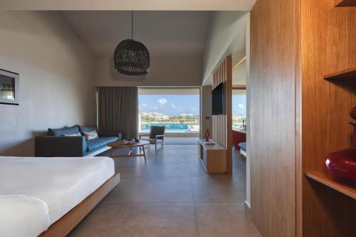 a bedroom with a bed and a living room at Castello Infinity Suites - Adults Only in Agia Pelagia