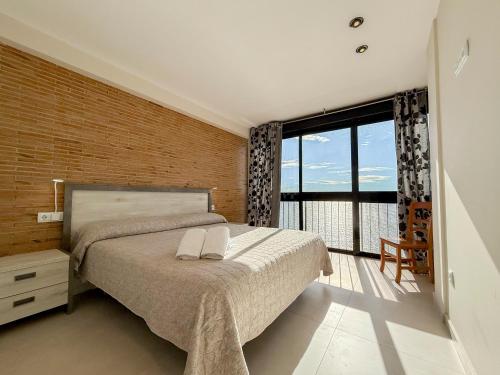 a bedroom with a large bed and a large window at Apartamentos Colón - Grupo Antonio Perles in Calpe