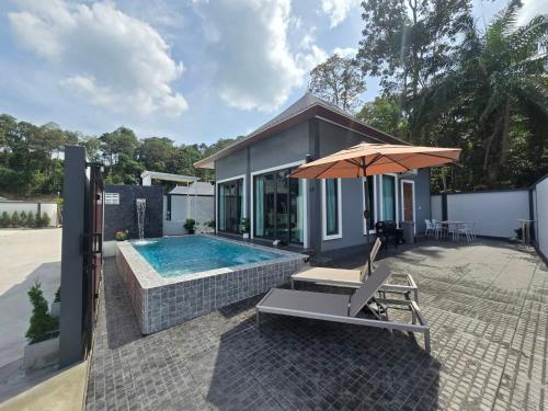 a house with a swimming pool and an umbrella at TiTIME POOL VILLA in Ao Nang 