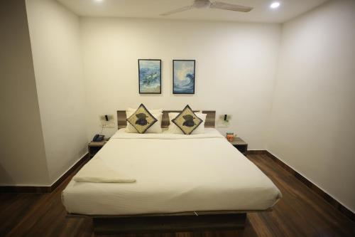 Bett in einem Zimmer mit zwei Bildern an der Wand in der Unterkunft Hillside Aqua in Bhubaneshwar