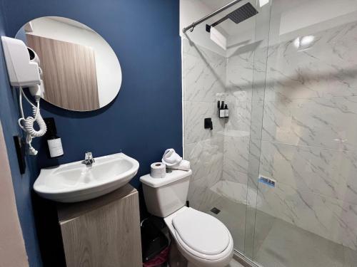 a bathroom with a toilet and a sink and a shower at Moore 45 Tu Espacio Comodo en Medellín in Medellín