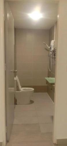 a bathroom with a toilet and a phone on the wall at JR Residence in Kota Kinabalu