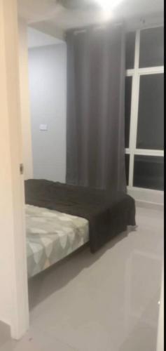un petit lit dans une chambre avec une fenêtre dans l'établissement JR Residence, à Kota Kinabalu
