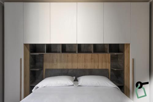 a bedroom with a bed with white cabinets at HOTIDAY Bormio Apartments in Bormio