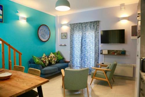 a living room with a blue couch and a table at Casa Anthos free parking in Chania Town
