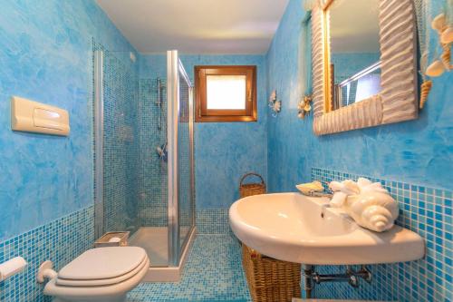a blue bathroom with a sink and a shower at Villa Molara Home - By Searly in Punta Molara