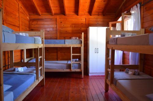a room with three bunk beds in a cabin at Gosén Cabañas Sanagasta in Villa Bustos