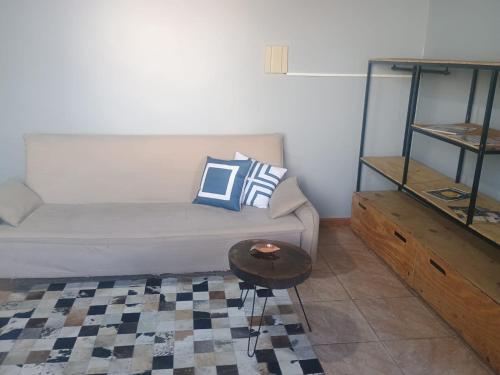 un soggiorno con un divano e un tavolo di Apto Confortável e espaçoso 02 a Cachoeira do Sul