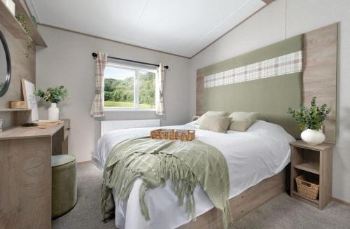 ein Schlafzimmer mit einem großen Bett und einem Fenster in der Unterkunft Ruda Holiday Park in Croyde