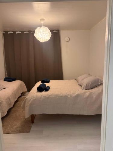 Un dormitorio con dos camas y una lámpara de araña. en Elfs Retreat close to Santa Claus Village, en Rovaniemi