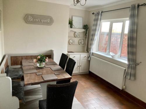 ein Esszimmer mit einem Holztisch und Stühlen in der Unterkunft 3 bedroom home with parking in Willaston