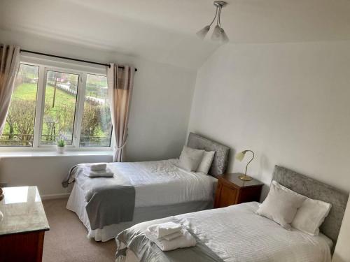 ein Schlafzimmer mit zwei Betten und einem Fenster in der Unterkunft 3 bedroom home with parking in Willaston