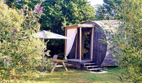 " village tonneaux de tirpoil " في Montilliers: منزل خارجي خشبي مع طاولة وكرسي