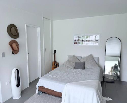 Un dormitorio blanco con una cama y un espejo. en Potts Point Cozy Studio Near Parks Water, en Sídney