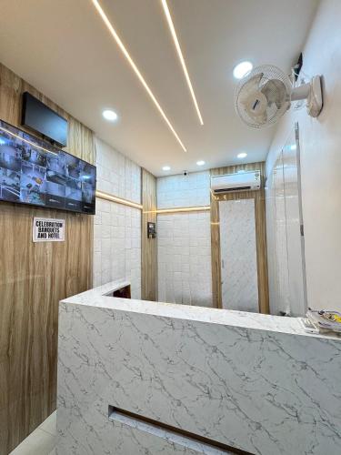 a bathroom with a marble counter and a shower at Celebration Banquets and Hotel in Rānīganj