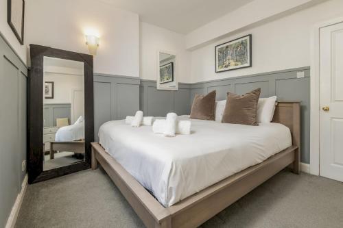 a bedroom with a large white bed with a mirror at Kincaple Garden Flat - Kincaple in Guard Bridge