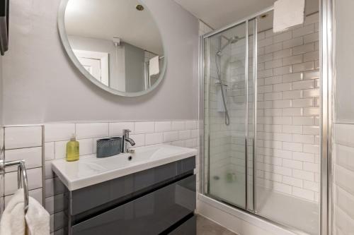 a white bathroom with a sink and a mirror at Kincaple Garden Flat - Kincaple in Guard Bridge
