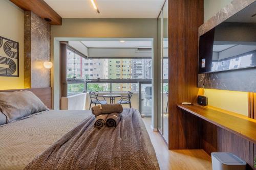 una camera da letto con un letto e una grande finestra di Handy Paraíso condomínio com piscina ao lado do Ibirapuera a San Paolo