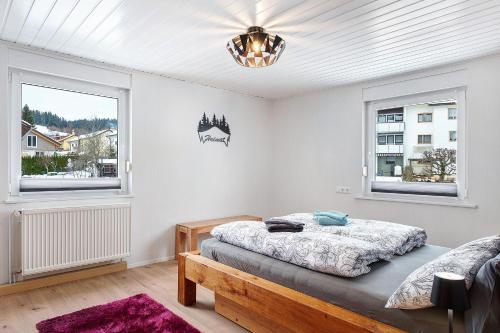a bedroom with a bed and two windows at Auszeit Schwarzwald in Breg