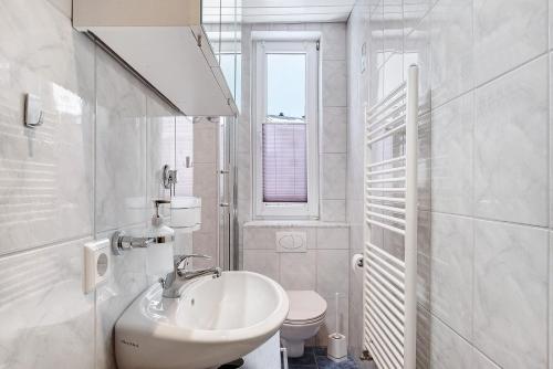 a white bathroom with a sink and a toilet at Auszeit Schwarzwald in Breg