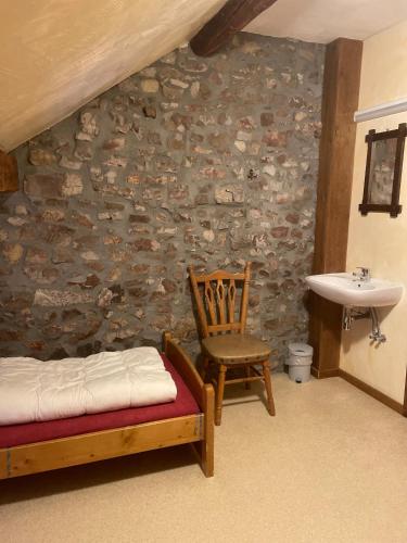 a bedroom with a sink and a bed and a chair at Fermette Erpigny in Fasol