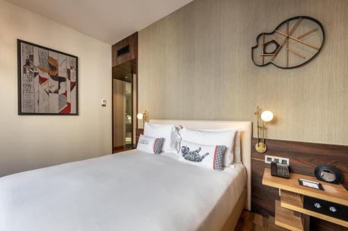 a bedroom with a large white bed and a mirror at Hyatt Centric Gran Via Madrid in Madrid
