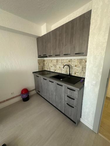 una cucina vuota con lavandino e armadi in legno di Apartamente Viglo Boutique Complex a Baia Mare