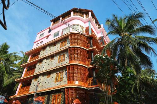 a tall building with a pink at Aditi Ayurveda Panchkarma Retreat in Vilinjam