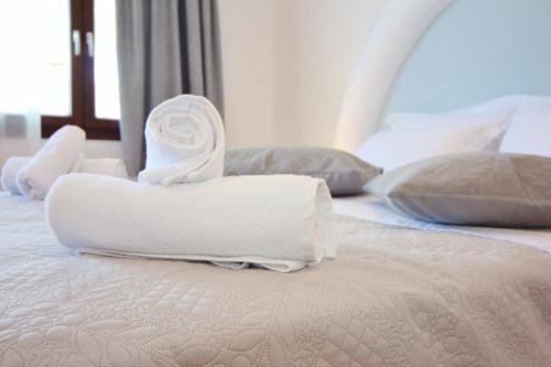 a bed with white towels on top of it at Ifestos Villa in Fira