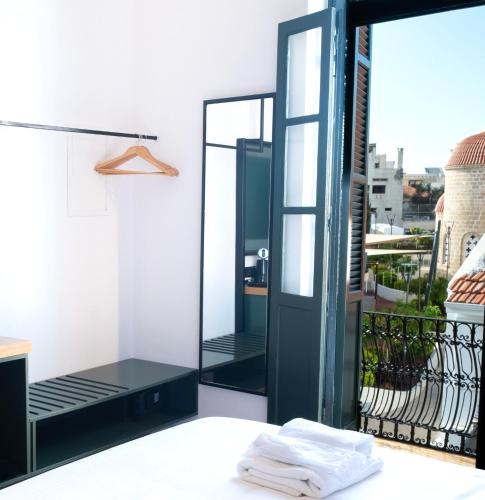 a room with a mirror and a balcony at Kentrikon 1924 Boutique Hotel, Old Town in Paphos