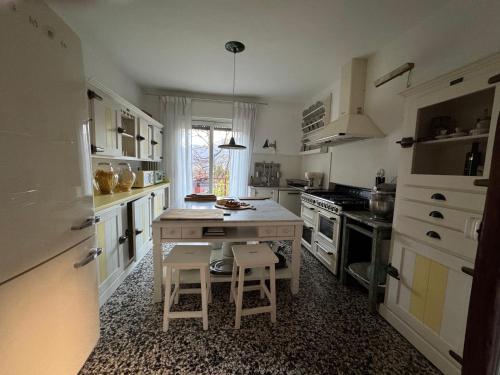 a kitchen with a table and two stools in it at Le Vetrate sul Lago Lake Como Amazing View in Nesso