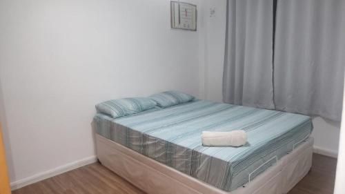 a small bed in a room with a window at 2 Qts próx Vila Militar, Sulacap e Campo dos Afonsos in Rio de Janeiro