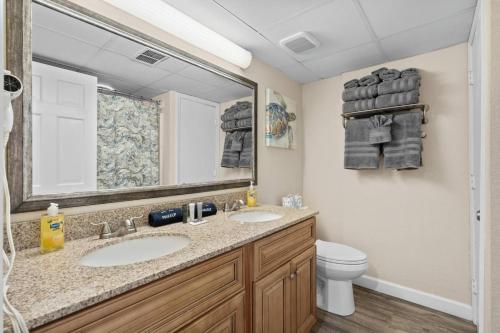 een badkamer met een wastafel, een toilet en een spiegel bij Beach Cove Resort Unit 423 Oceanfront Condo with Balcony in Myrtle Beach